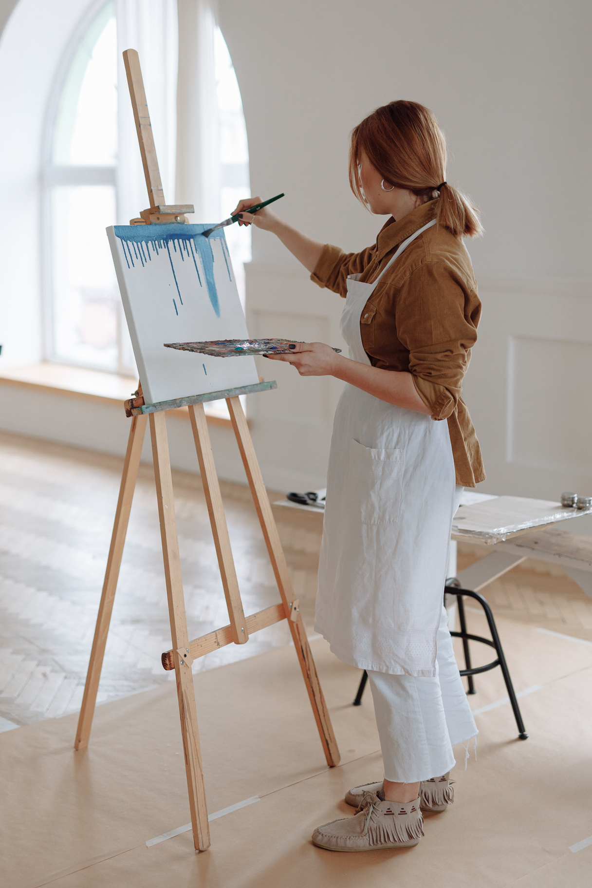 Woman in Brown Long Sleeves Painting on a Canvas